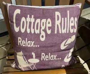 a cushion with the words saying that cottage rules are relax and relax