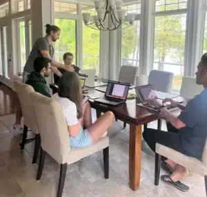 Productive Shop team members sit around the table with their computers open